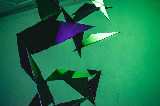 锋利的三角形钢形状上有绿色和紫色的照明.